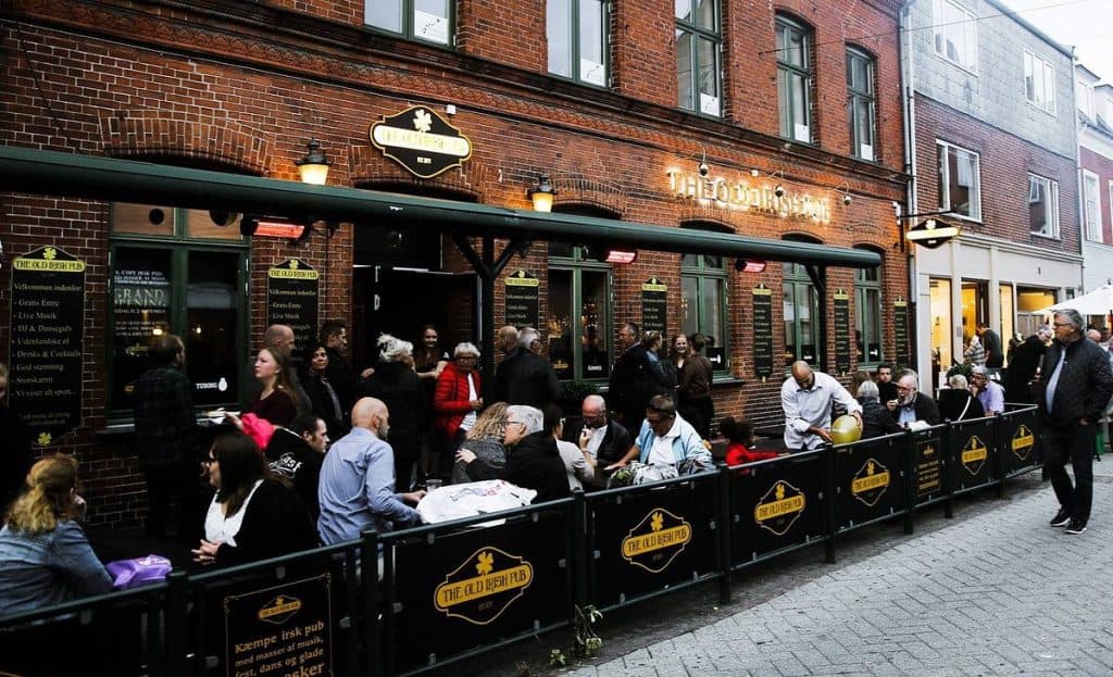 Et travlt udendørs opholdsområde på en murstenspub ved navn 