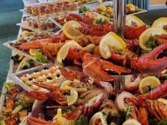Byliv.nu: Et buffetbord med etager af hummer, citronskiver og forskellige forretter arrangeret på bakker.