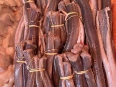 Byliv.nu: Bunter af rå fiskefileter bindes sammen med gule gummibånd, vist på en isleje.